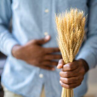 Celiac Disease And Gluten Intolerance. Man Holding Spikelet Of Wheat